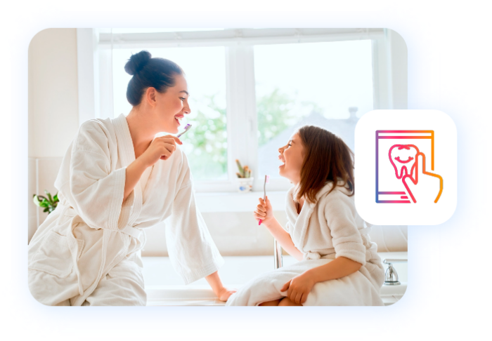 Madre e figlia curano la propria igiene orale divertendosi.